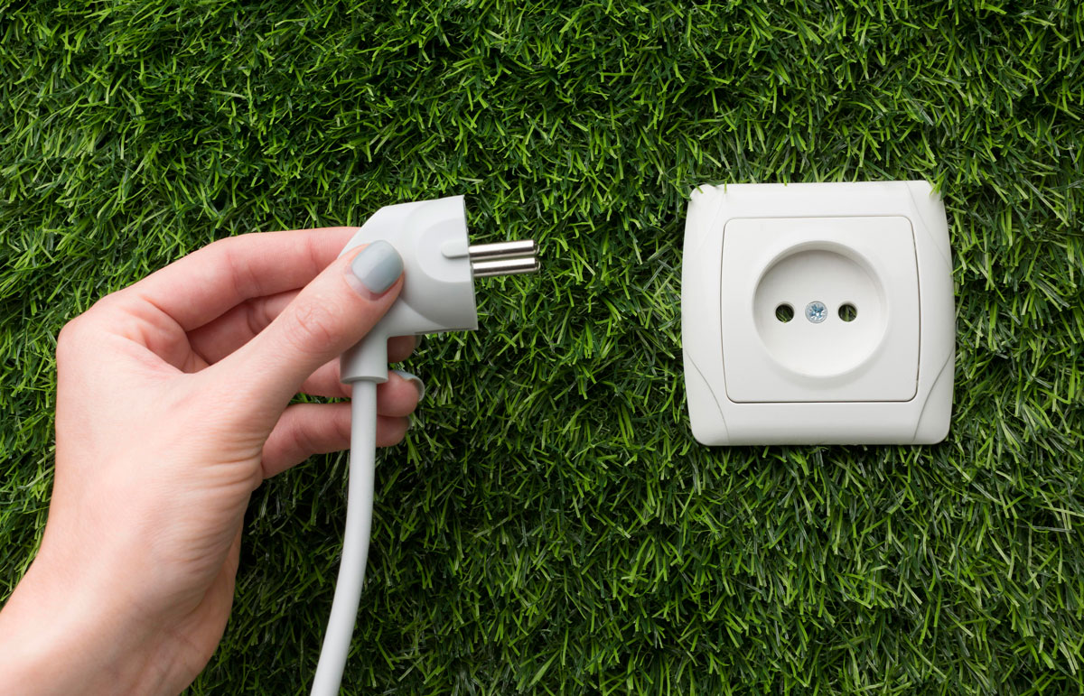 Desconectando un enchufe para reducir la huella de carbono